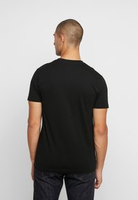 Black short-sleeve T-shirt with a classic crew neck, made of smooth cotton fabric, featuring a straight hem and no visible patterns or accents.