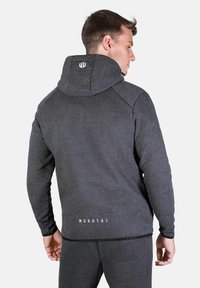 Šedá mikina s vysokým golierom, slim fit a logom vzadu. Značková tkanina s jemnou textúrou a kontrastným prešívaním pozdĺž ramien.