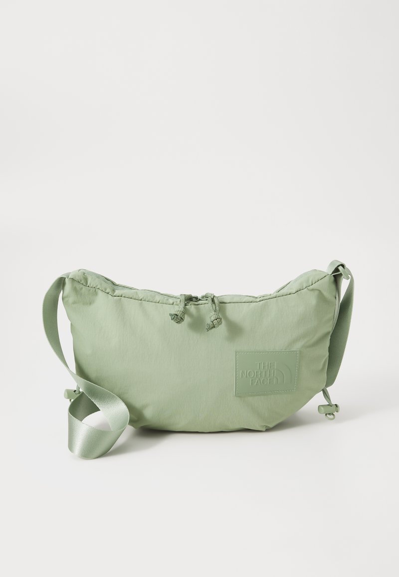 Hellgrüne, puffige Schultertasche aus weichem Stoff, mit einem strukturierten Logo-Patch, Kordelzugverschluss und einem Satinstreifen.