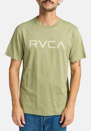 Camiseta de algodón verde oliva con un gran logo en gris claro "RVCA" en el frente. Mangas cortas y un corte holgado.