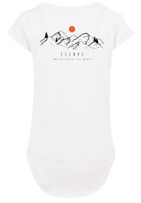 Witte t-shirt met een grafiek van een berg en een boom, met een rode zon. Tekst leest "ONTZETTEN EN ONTDEKKEN DE WERELD." Zacht, lichtgewicht stof.