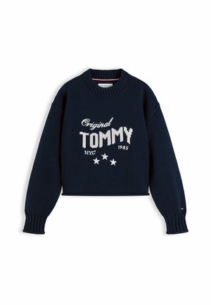 Mørkeblå strikket sweater med ribstrikkede ærmekanter og krave, hvid tekst med teksten "Original TOMMY NYC 1985," og tre hvide stjerner under teksten.