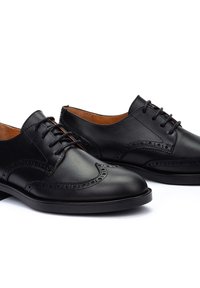 Chaussures habillées en cuir noir avec un design brogue et des détails perforés, lacets plats, bout en amande et une texture lisse.