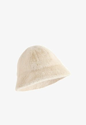 Chapeau seau en fausse fourrure de couleur crème avec une texture douce et duveteuse et une large bordure inclinée vers le bas, conçu pour la chaleur et le confort.