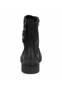 Stivale alla caviglia in pelle nera con finitura texture, chiusura laterale con zip e dettaglio decorativo a pressione. Suola in gomma spessa e punta rinforzata.