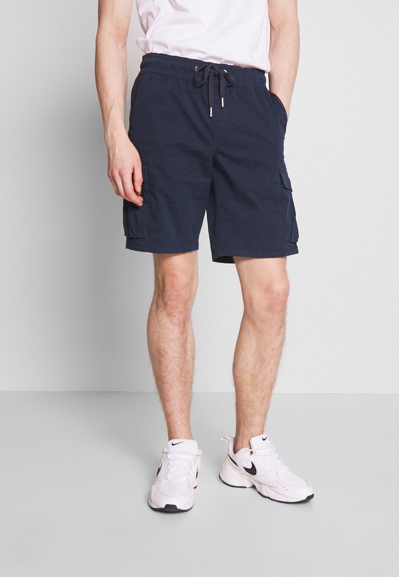 Shorts cargo bleu marine avec taille à cordon, deux poches latérales et une poche patch sur la jambe, fabriqués en tissu léger.