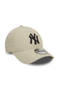 Casquette de baseball beige en coton avec une visière courbée. Présente un logo "NY" noir brodé à l'avant et une sangle réglable à l'arrière.