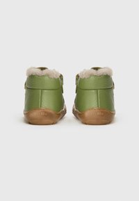 Groene leren enkelboots met zachte beige bontvoering en tan rubberen zolen. Voorzien van dubbele verstelbare banden voor een veilige pasvorm.