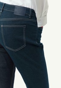Dunkelblaue Denim-Jeans mit niedrigem Bund, klassischem Fünf-Taschen-Design und kontrastierenden Nähten. Strukturierter Taillenschild mit Logo.