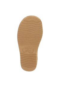 Beige rubberen zool met een gestructureerd oppervlak met golfpatronen en richels. Geïmpregneerde branding met de tekst "WARMBAT AUSTRALIA."