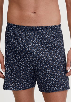Marineblaue Badeshorts mit einem sich wiederholenden, geschwungenen Muster in Orange, Weiß und Hellblau. Elastischer Bund und lockere Passform für zusätzlichen Komfort.