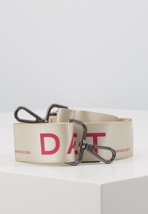 Beige vævet bælte med røde bogstaver og sorte metal karabiner clips i begge ender, sammenrullet på en hvid overflade.