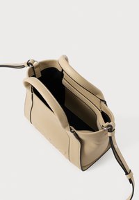 Bolsa de mão de couro bege com alças duplas, uma alça destacável e um interior espaçoso preto com um bolso zipado.