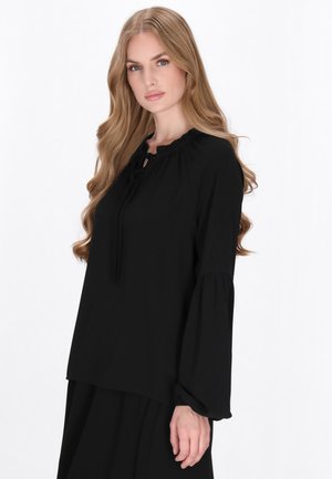 Zwarte blouse met lange, bolle mouwen, een geschulpte halslijn en een strikdetail aan de voorkant. Gladde stof met een losse pasvorm.