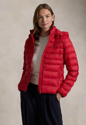Giacca a vento rossa con zip frontale, cappuccio e texture trapuntata. Dotata di tasche laterali e di un piccolo logo sul lato superiore sinistro.