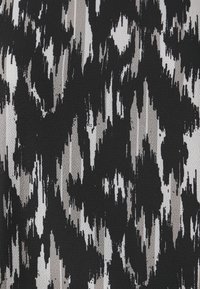 Zwart en crèmekleurige stof met een gedurfde, abstracte patroon van scherpe, verticale lijnen en een gestructureerd oppervlak. Ideaal voor bekleding of kleding.