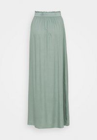 Jupe longue verte en tissu doux, dotée d'une taille élastique avec des détails froncés, silhouette fluide et sans motifs visibles.