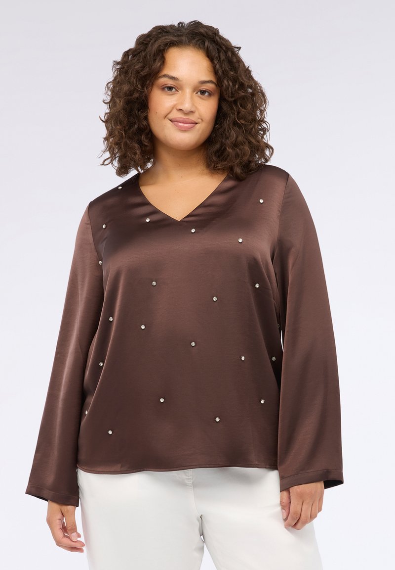 Top in satin marrone con scollatura a V e maniche lunghe, caratterizzato da dettagli in argento sparsi. Texture liscia, vestibilità morbida e orlo piatto.