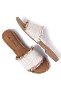 Woven white slide sandals with tan leather insole and a low heel. Features decorative gold and brown accents along the strap edges.