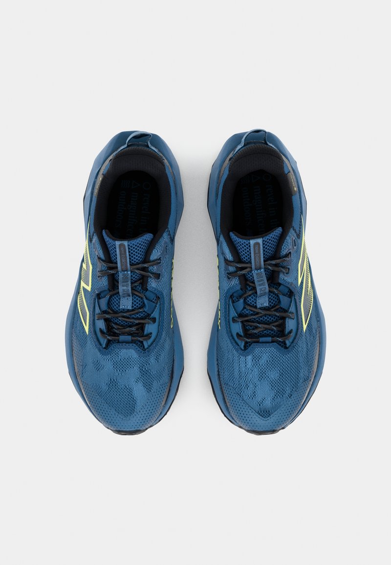 Baskets de course bleu en mesh avec une surface texturée, lacets noirs et accents jaunes sur les côtés. Embout arrondi et semelle rembourrée.