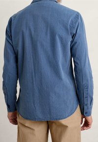 Blau gestreift, langärmliges Hemd aus weichem Stoff, mit abgerundetem Saum und geknöpften Manschetten mit subtilen Stickdetails.