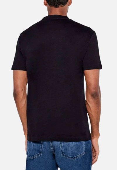 T-shirt noir à manches courtes, col rond, en coton, texture lisse, design ajusté, vu de dos, associé à un jean bleu.