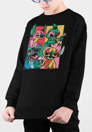 Sweatshirt noir avec un imprimé graphique coloré de personnages de dessins animés répartis en quatre sections, affichant diverses expressions et activités.