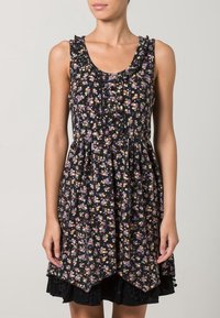 Robe noire sans manches avec imprimé floral multicolore, petit motif, encolure à volants, devant boutonné et ourlet asymétrique sur bordure en dentelle noire.