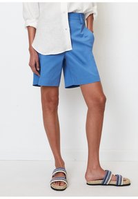 Lyseblå bomuldsshorts med et skræddersyet design, sidelommer og en afslappet pasform, kombineret med vævede espadrilles med marineblå detaljer.