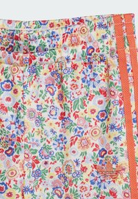 Floral-patterned fabric in yellow, red, blue, and green; features an orange stripe and a small embroidered logo. Smooth texture.