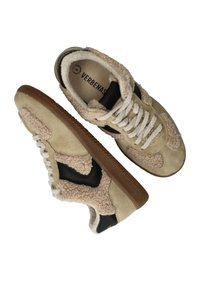 Beige en zwarte sneakers met suède en nep-sherpa accenten. Ronde neus, gestructureerde gumzool en traditionele vetersluiting met witte veters.