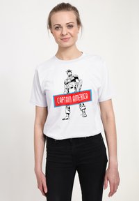 Bílé tričko s černobílou ilustrací svalnaté postavy v oblečení s hvězdami, s červeným nápisem "CAPTAIN AMERICA".
