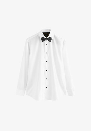 White dress shirt made of cotton, featuring long sleeves, a black bow tie, and black buttons down the front.