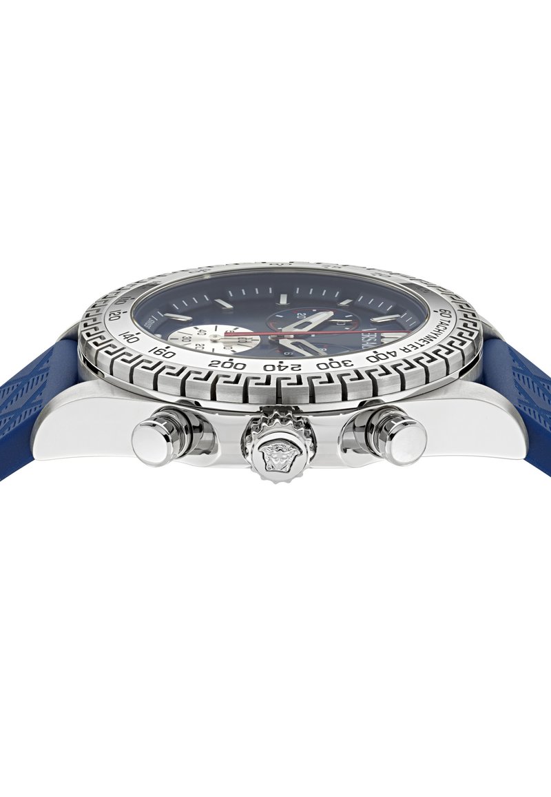Vue de côté d'une montre chronographe argentée avec un bracelet bleu, une lunette gravée et une couronne détaillée avec le logo.
