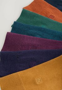 Cinque paia di calze in vari colori: arancione, verde, teal, viola e giallo senape. Morbido al tatto con accenti di logo ricamati.