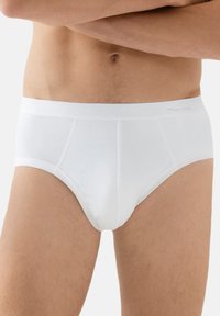 Slip in cotone bianco con vestibilità aderente, caratterizzato da una vita morbida e dettagli di cucitura minimi, per un aspetto liscio e senza cuciture.