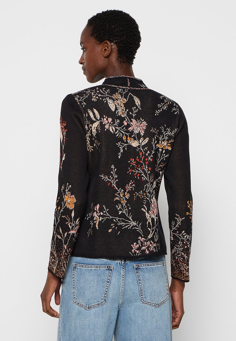 Zwarte geborduurde jas met bloempatronen in roze, rood en geel. Lange mouwen en een getailleerd silhouet van gestructureerde stof.