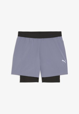 Pantaloncini sportivi a doppio strato con uno strato interno nero a compressione e uno strato esterno viola chiaro con un logo Puma bianco.