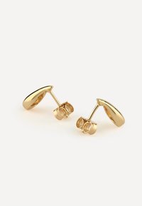 Boucles d'oreilles en or en forme de goutte d'eau avec une finition polie, dotées d'un fermoir à tige et papillon pour un port sûr. Texture lisse et design épuré.