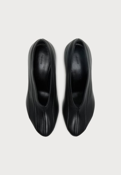 Ζευγάρι μαύρα δερμάτινα παπούτσια τύπου slip-on με στρογγυλεμένο μυτερό μέρος και κεντρική ραφή, εμφανιζόμενα από πάνω σε γκρι φόντο.