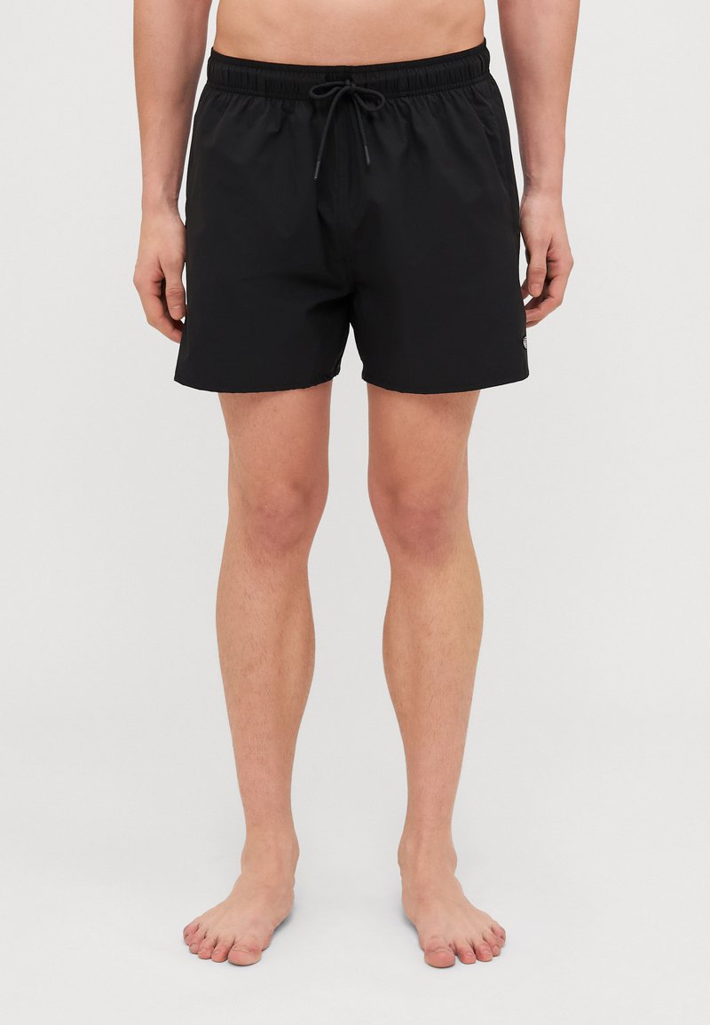 Pantalones de baño negros con banda elástica en la cintura y cordón. Largo corto, textura suave, con un pequeño logo en el lado.