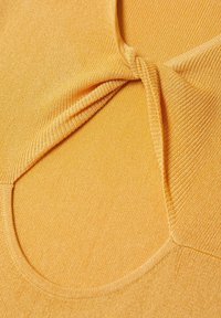 Tissu tricoté jaune présentant une texture lisse, un col rond et un détail de design torsadé au centre.