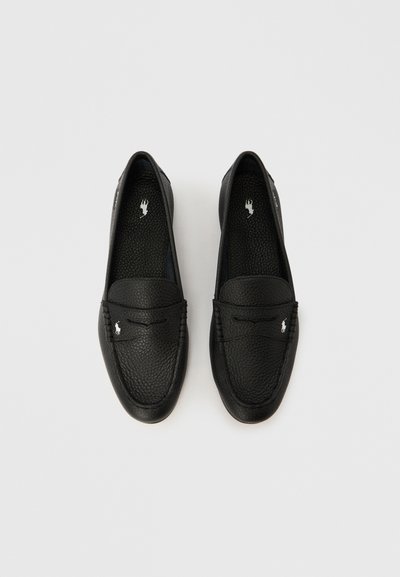 Mustad nahast mõõtmekingad tekstureeritud pinnaga, millel on libisemisvastane disain, nähtav õmblus ja küljele kinnitatud väike metallist logo.