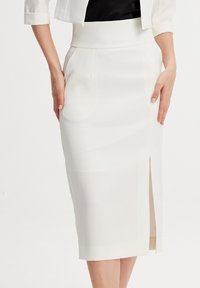 Jupe crayon blanche en tissu lisse, dotée d'une fente sur le côté et d'une taille cintrée. Design simple sans ornements visibles.