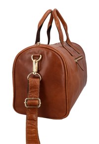 Braune Leder-Duffelbag mit doppelten Griffen, einem abnehmbaren Schultergurt mit goldenen Verschlüssen und einer seitlichen Reißverschlusstasche.