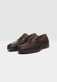 Mocassini in pelle marrone con finitura liscia, dotati di dettagli cuciti e tacco basso. Design classico con stile slip-on.