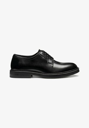 Zapato Oxford de vestir de cuero negro con cierre cerrado, punta redondeada y tacón apilado bajo, mostrado de perfil sobre fondo blanco.