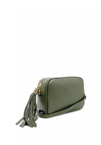 Bolso cruzado de cuero en verde oliva con forma rectangular, cierre dorado y un adorno de borlas decorativas. Textura suave.