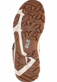 Suela de bota de senderismo de goma marrón con surcos profundos y angulados. Detalles de mediacanva blancos y marca "Jack Wolfskin" cerca del talón. Superficie texturizada.