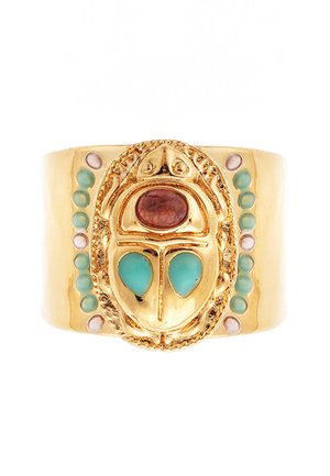 Gold cuff ring featuring a scarab design. Accented with turquoise and garnet stones, and small white details along the side. Smooth texture.